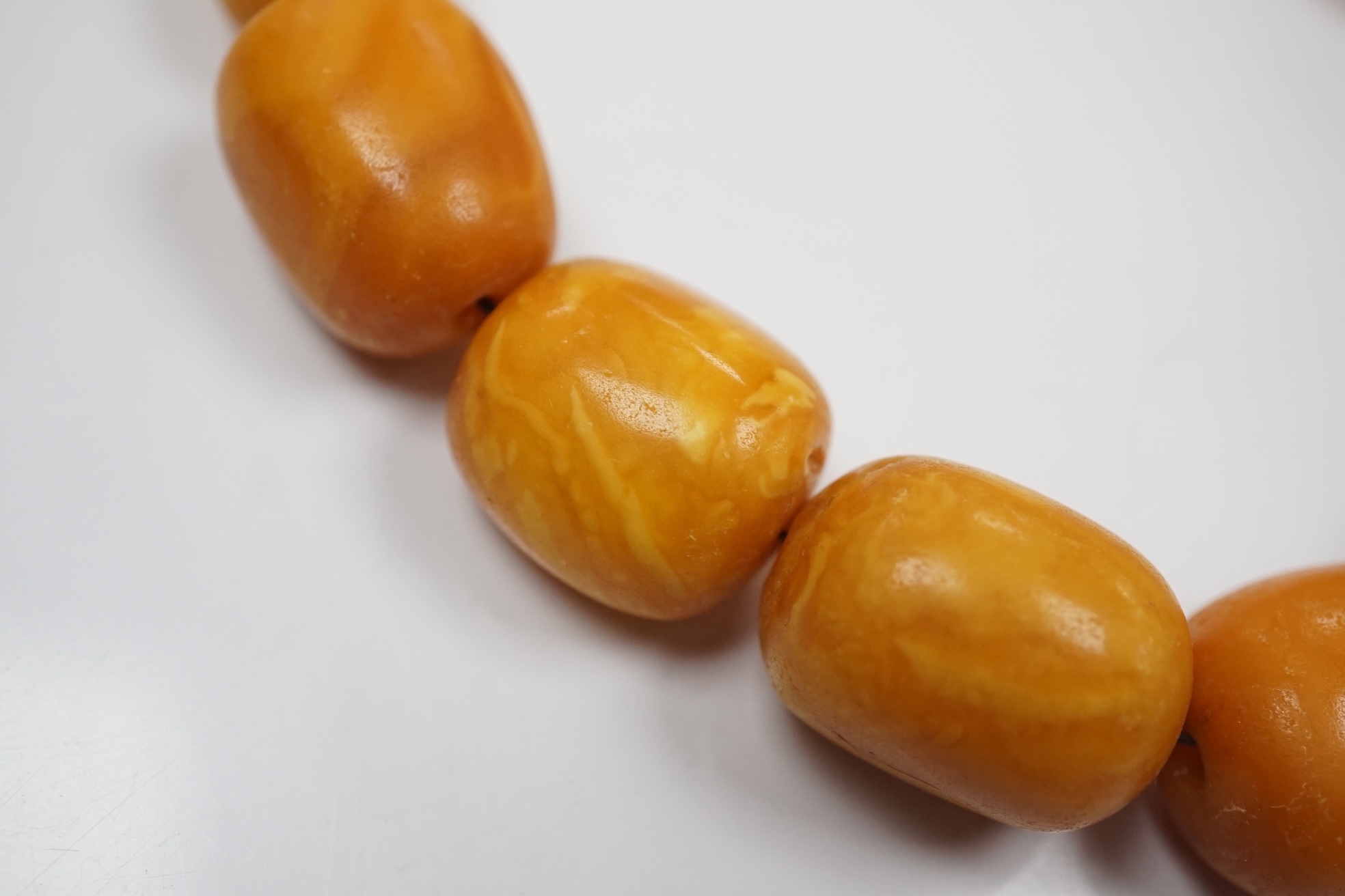 A single strand graduated oval amber bead necklace, 42cm, gross weight 49 grams. Condition - poor to fair